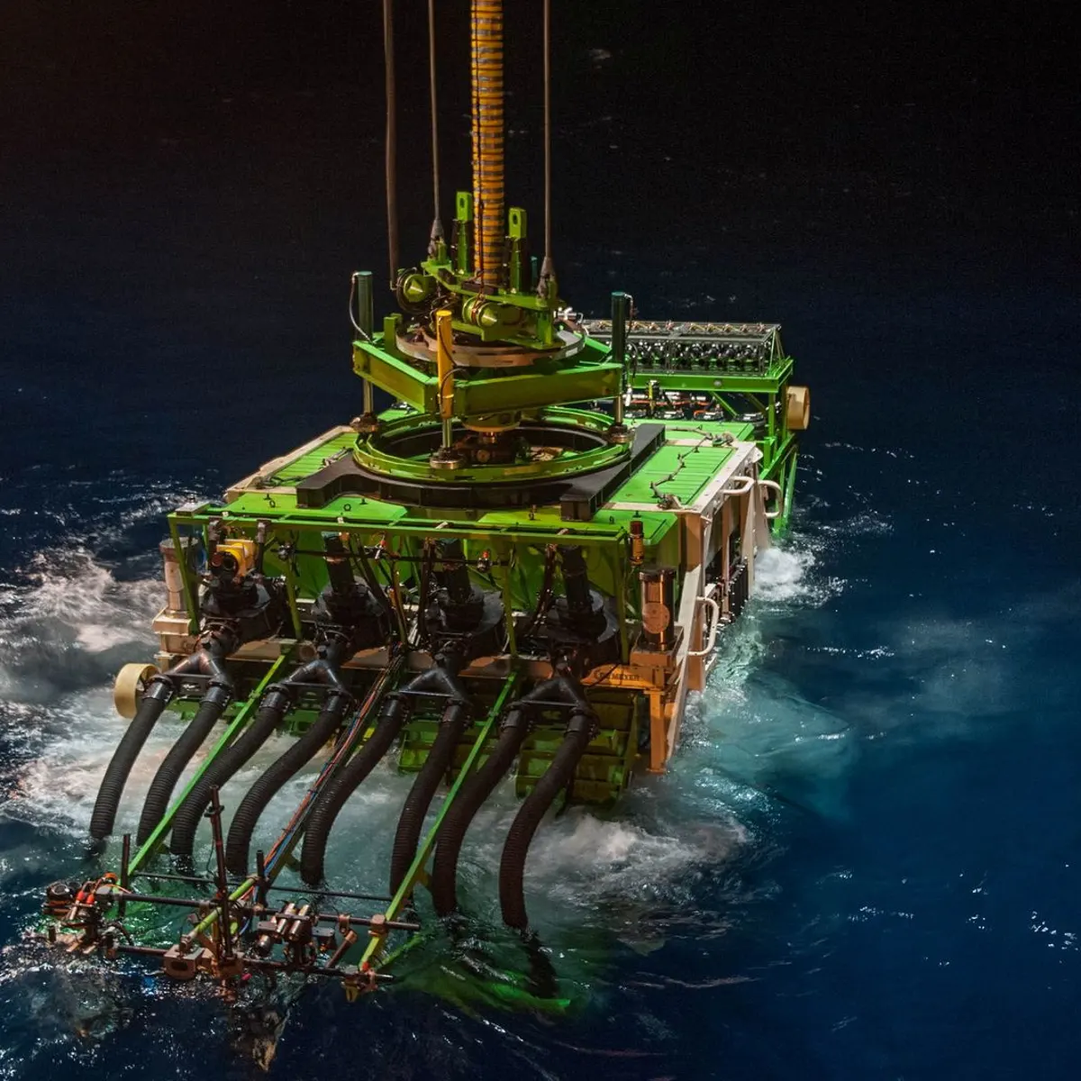 A deep sea mining subsea collector being lowered into the water via the Collector Launch and Recovery System